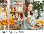 Teenage girl choosing nougat in grocery store. Стоковое фото, фотограф Яков Филимонов / Фотобанк Лори