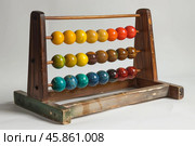 Old wooden abacus showing colorful beads for calculating. Стоковое AI-изображение, AI-художник Иван Рябоконь / Фотобанк Лори