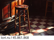 Empty stool standing next to bar in irish pub. Стоковое AI-изображение, AI-художник Иван Рябоконь / Фотобанк Лори