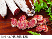 Chopped sausage fuet on wooden table. Стоковое фото, фотограф Яков Филимонов / Фотобанк Лори