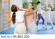 Woman and girl in gym perform basic elements of krav maga self-defense system. Стоковое фото, фотограф Яков Филимонов / Фотобанк Лори