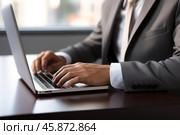 Businessman working on laptop in office, close up of hands typing. Стоковое AI-изображение, AI-художник Иван Рябоконь / Фотобанк Лори