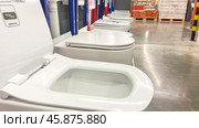 Plumbing, white toilets standing in a row in a store. Close-up, selective focus, side view, in Supermarket. Moscow February 07 2024, Стоковое фото, фотограф Скрипачев Антон / Фотобанк Лори