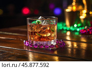 Sazerac cocktail celebrating mardi gras with ice and lime on wooden table. Стоковое AI-изображение, AI-художник Иван Рябоконь / Фотобанк Лори