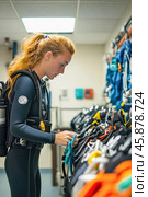 Scuba diver preparing equipment in diving center locker room. Стоковое AI-изображение, AI-художник Юрий Поздников / Фотобанк Лори