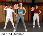 Girl in gym does exercises with kettlebell, lifts and lowers heavy kettlebell with one hand. Стоковое фото, фотограф Яков Филимонов / Фотобанк Лори
