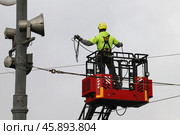 Монтажник на выдвижной автовышке устанавливает трос. Стоковое фото, фотограф Сергей Шелагин / Фотобанк Лори