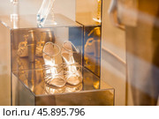 An elegant high-end shop window with golden shoes and evening lighting. The concept of shopping and sales. Стоковое фото, фотограф Photojuli / Фотобанк Лори