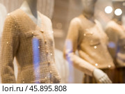 Blurred background. An elegant showcase of an elite store with stylish mannequins in clothes and evening lighting. The concept of shopping and sales. Стоковое фото, фотограф Photojuli / Фотобанк Лори