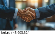 Handshake between two people dressed in business suits. This symbolizes reaching an agreement, establishing trust, or starting a partnership. The scene takes place in an office or business setting, with soft, slightly blurred lighting, which adds professionalism and warmth to the frame. The hands are firmly clasped, which emphasizes the confidence and mutual respect between the participants.The participants' suits are classic, and the cuffs of their shirts are neatly visible from under the sleeves. The light falls on the hands, highlighting details such as the texture of the skin and fabric, giving the image dynamism and realism. Стоковое AI-изображение, AI-художник Анна Кривицкая / Фотобанк Лори