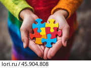 Child holding colorful puzzle pieces, representing autism awareness. Стоковое AI-изображение, AI-художник Иван Рябоконь / Фотобанк Лори