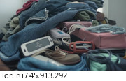 A big pile of things collected from a landfill. The concept of overconsumption, overspending and buying unnecessary things and clothes. Reusing second-hand. A world global problem. Стоковое AI-видео, аниматор ALLA YURTAYEVA / Фотобанк Лори