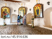Pilgrims in the Holy Dormition Pskovo-Pechersky (Pskov-Caves) monastery next the old orthodoxy icons (2024 год). Редакционное фото, фотограф FotograFF / Фотобанк Лори