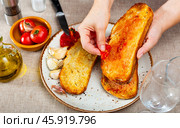 Spanish Pan con Tomate - cook rubs bread with tomatoes. Стоковое фото, фотограф Яков Филимонов / Фотобанк Лори