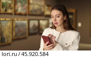 Young woman takes a photo in a museum. Visitor scans the qr code to get information about the painting and the artist. Стоковое видео, видеограф Яков Филимонов / Фотобанк Лори