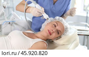 Young woman undergoing skin therapy session in modern cosmetology clinic. Aesthetician applying atomized nutrients with airbrush onto client face to enhance and revitalize complexion. Стоковое видео, видеограф Яков Филимонов / Фотобанк Лори