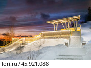 Krasnoyarsk, Russia observation deck in gremyachaya Griva Park 2024 12 31. Picturesque snow-covered steps lead to a scenic viewing platform surrounded by nature at dusk. Редакционное фото, фотограф Владимир Разгуляев / Фотобанк Лори