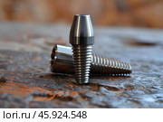 Dental implant standing on stone surface with other parts lying down. Стоковое AI-изображение, AI-художник Иван Рябоконь / Фотобанк Лори