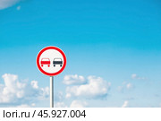 Traffic Laws. Attention. Overtaking is prohibited. A road sign on a metal pole against a background of blue sky and white clouds. Стоковое фото, фотограф Photojuli / Фотобанк Лори