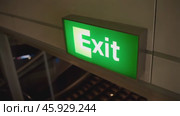 Green exit sign glowing in dark building. Стоковое видео, видеограф Данил Руденко / Фотобанк Лори