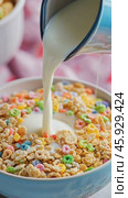 Milk pouring into bowl of colorful cereal. Стоковое AI-видео, аниматор Юрий Поздников / Фотобанк Лори
