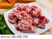 Raw chicken gizzards and greens on wooden surface. Стоковое фото, фотограф Яков Филимонов / Фотобанк Лори