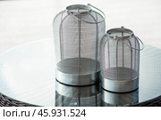 Interior details. A minimalistic composition of the modern interior of the veranda of a country house. Two stylish iron candlesticks on a glass table. The patio. Стоковое фото, фотограф Photojuli / Фотобанк Лори