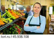 Middle-aged saleswoman standing in front of counter in grocery store. Стоковое фото, фотограф Яков Филимонов / Фотобанк Лори