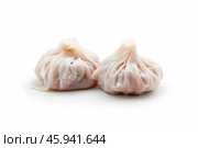 Two xiaolongbao dumplings resting on white background. Стоковое AI-изображение, AI-художник Иван Рябоконь / Фотобанк Лори