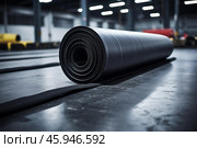 Roll of industrial material lying on factory floor. Стоковое AI-изображение, AI-художник Иван Рябоконь / Фотобанк Лори