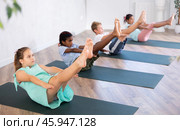 Girl perform boat asana - Paripurna navasana. Comprehensive hatha yoga class in mini group. Стоковое фото, фотограф Яков Филимонов / Фотобанк Лори