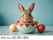 A holiday banner. A cute Easter bunny is peeking out of an Easter egg, and colorful eggs are scattered around. The concept of happy Easter. Стоковое AI-изображение, AI-художник Photojuli / Фотобанк Лори