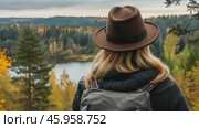 Adventurer among an Autumn Landscape. Back View of Young Woman Wearing Knitted Hat, Jacket, Backpack in Forest Woods Nature. Beauty and Adventure. Vibrant colorful fall scenery. Travel hike. Journey. Стоковое AI-видео, аниматор Марина Демидюк / Фотобанк Лори