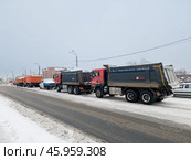 Грузовики на заснеженной городской улице стоят в очереди на снегоплавильную станцию. Обводный канал. Санкт-Петербург. Редакционное фото, фотограф Ольга Визави / Фотобанк Лори