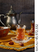 Azerbaijani black tea in armudu tea glass. Atmosphere of Baku and Eastern traditions. Oriental cuisine. Cozy atmosphere in the caucasus cafe. Стоковое фото, фотограф Андрис Салминьш / Фотобанк Лори