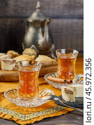 Azerbaijani black tea in armudu tea glass. Atmosphere of Baku and Eastern traditions. Oriental cuisine. Cozy atmosphere in the caucasus cafe. Стоковое фото, фотограф Андрис Салминьш / Фотобанк Лори