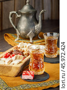 Azerbaijani black tea in armudu tea glass. Atmosphere of Baku and Eastern traditions. Oriental cuisine. Cozy atmosphere in the caucasus cafe. Стоковое фото, фотограф Андрис Салминьш / Фотобанк Лори