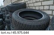 Storage of discarded old car tires outdoors, showcasing a pile of used tires ready for recycling. Highlighting environmental concerns and rubber waste management. Стоковое фото, фотограф Ivan Murauyou / Фотобанк Лори
