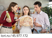 Daughter chose some pizzas in store, and quarrels with parents over choice of food. Стоковое фото, фотограф Яков Филимонов / Фотобанк Лори