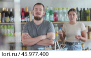 Wife stands behind husband and yells at companion in shop. Стоковое видео, видеограф Яков Филимонов / Фотобанк Лори