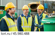 Waste recycling center workers discussing and smiling during their work shift. Стоковое AI-изображение, AI-художник Юрий Поздников / Фотобанк Лори