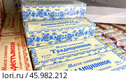 Moscow December 04 2024, Butter in packaging on a store counter. Concept of increasing prices for butter. Refrigerator in a grocery store with briquettes of natural butter. Редакционное фото, фотограф Скрипачев Антон / Фотобанк Лори