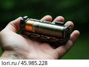 Technician holding disassembled lithium battery showing internal components. Стоковое AI-изображение, AI-художник Иван Рябоконь / Фотобанк Лори