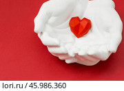Stylish banner. In his hands, a red heart on a red background is made of plaster. World Health, Love and Insurance Day. World Heart, Health and Organ Donor Day. Стоковое фото, фотограф Photojuli / Фотобанк Лори