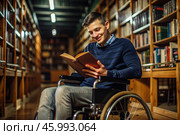 Disability. A child with disabilities in a wheelchair is reading a book in the library. Healthcare and medicine. Стоковое AI-изображение, AI-художник Photojuli / Фотобанк Лори