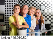 Pensive elderly grandparents together with their children solve a puzzle in quest room. Стоковое фото, фотограф Яков Филимонов / Фотобанк Лори