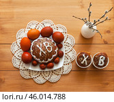 Easter composition with homemade Easter cakes on lace handmade napkin, pussy willow branches and painted red Easter eggs on wooden table. On Easter cakes russian letters ХВ mean Christ is Risen. Стоковое фото, фотограф Виктория Катьянова / Фотобанк Лори