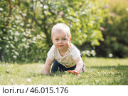 Portrait of a 1-year-old little boy outdoors. A happy child walks in the spring park. Happy childhood and fatherhood. Стоковое фото, фотограф Photojuli / Фотобанк Лори