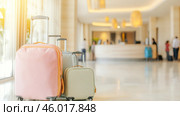 Travel bags in modern hotel lobby with blurred receptionists. Стоковое AI-изображение, AI-художник Анастасия Золотницкая / Фотобанк Лори