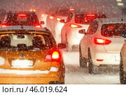 Затрудненное движение автомобилей в пробке  в зимний снежный вечер. Стоковое AI-изображение, AI-художник Сергей Никифоров-Гордеев / Фотобанк Лори